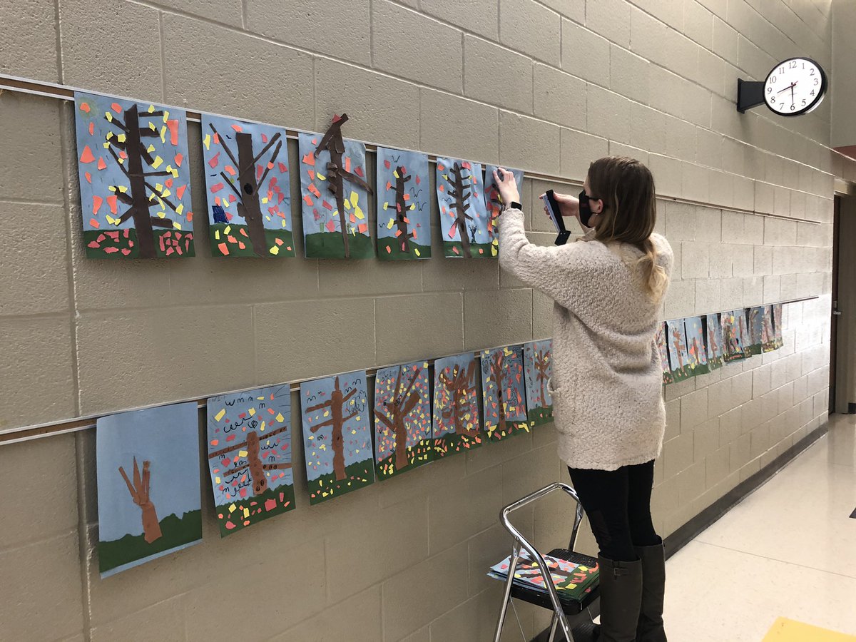 Miss Kolb is at it again... this time hanging 1st grade artwork. They each made a collage of a fall tree!  Our students are so creative!