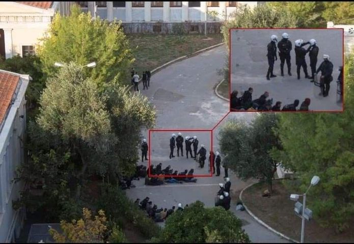 Κατά τη διάρκεια της σημερινής εισβολής στο Πολυτεχνείο: αστυνομικός έβγαζε σέλφι με τους προσαχθέντες δίκην «αιχμαλώτων» πίσω του.