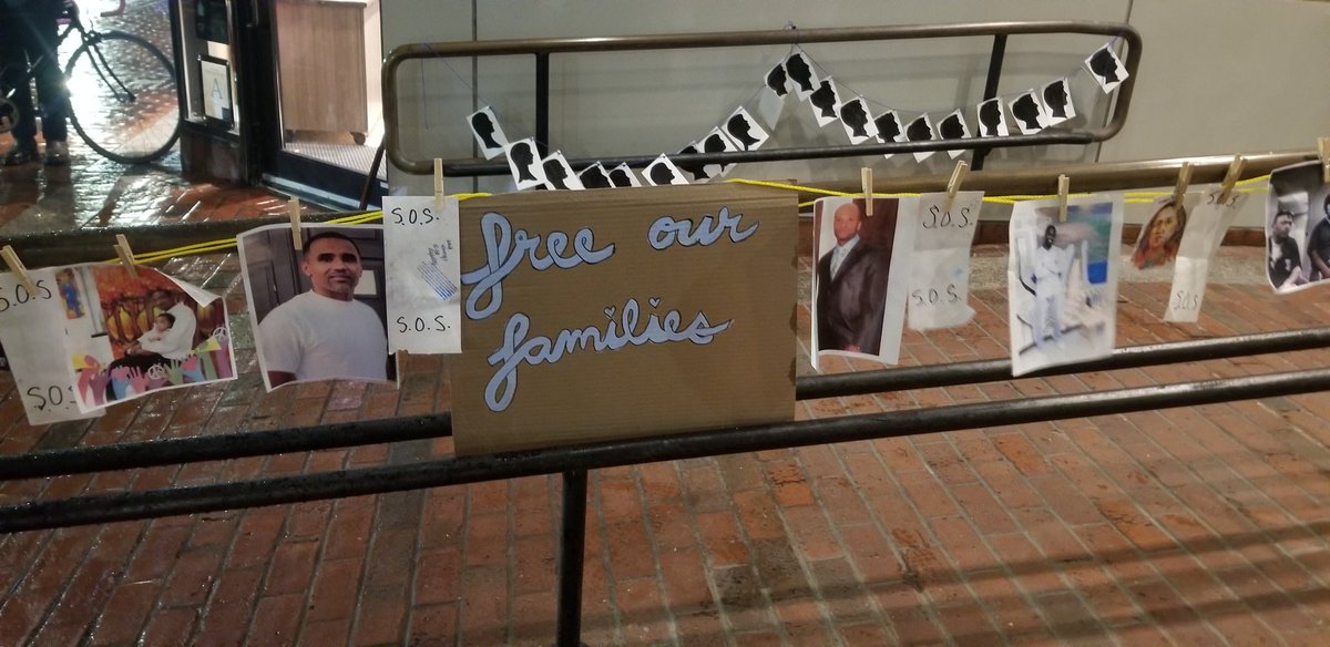 Free our families sign on a railing surround by pictures of incarcerated family members