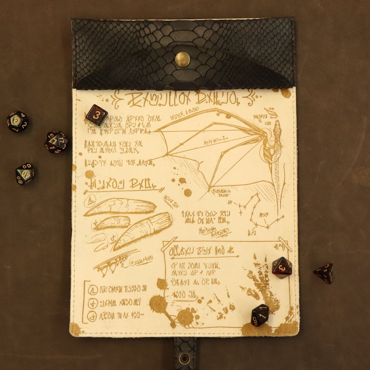 CeryneianA's tweet photo. The new #ttrpg Dragon Scroll is coming to the @SpeechlessBard shop on Sat. November 21! With creme white leather (engraved with my new design) on one side and dark dragon hide on the other, plus space for two sets of dice in the pouch! Time of launch will come up this week ๐ฒ https://t.co/5I2sLGmTau