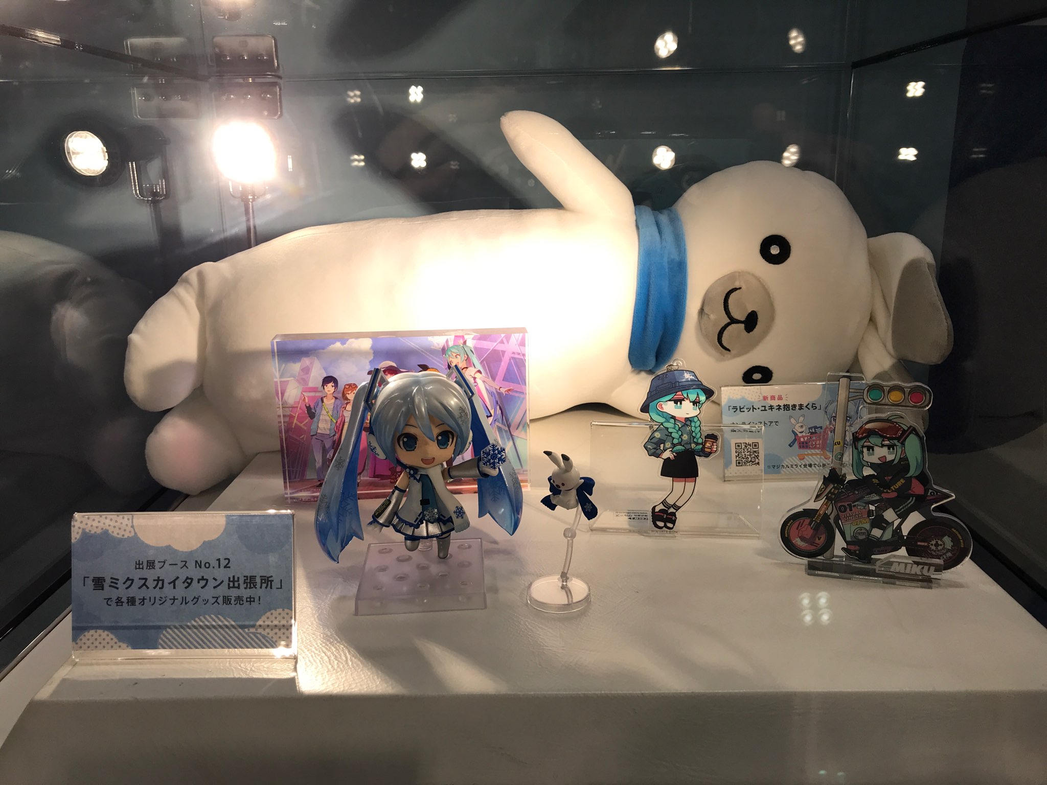 雪ミク 初音ミク 雪ミクスカイタウン マジカルミライ会場壁面のショーケースに涅槃スタイルのユキネ抱き枕を展示中 会場にお越しのみなさんはぜひガラス越しにもちもち感をご覧ください こちらは現在店舗とecサイトでお取り扱い中 チェックよろしく