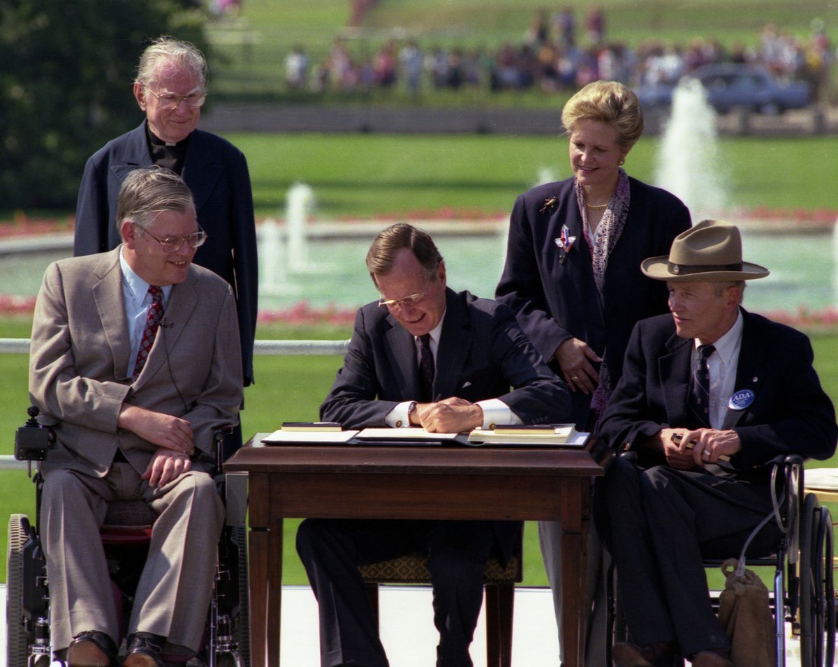 YAppelbaum's tweet photo. Two presidents, one desk.

In 1990, when George H.W. Bush signed the ADA into law, the photo captured the dignity of a president surrounded by those whose inherent worth he was ensuring would be protected by law.

If the second photo seems grotesque, it isn't because of the desk. https://t.co/tpYgEm3TBb