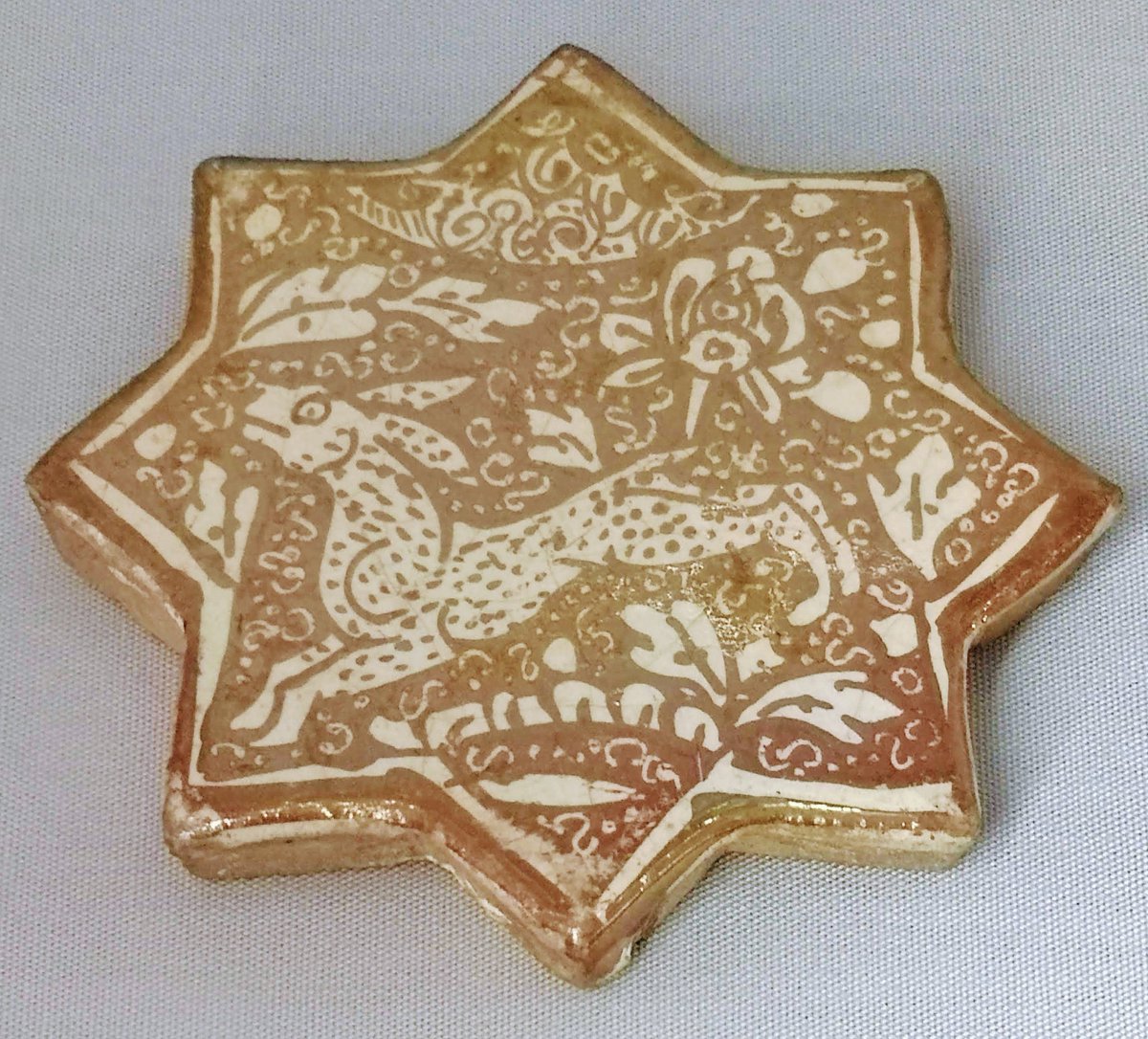 A 13th-century shaped tile with painted lustre, probably made Kashan, Iran, and now in the Royal Cornwall Museum.