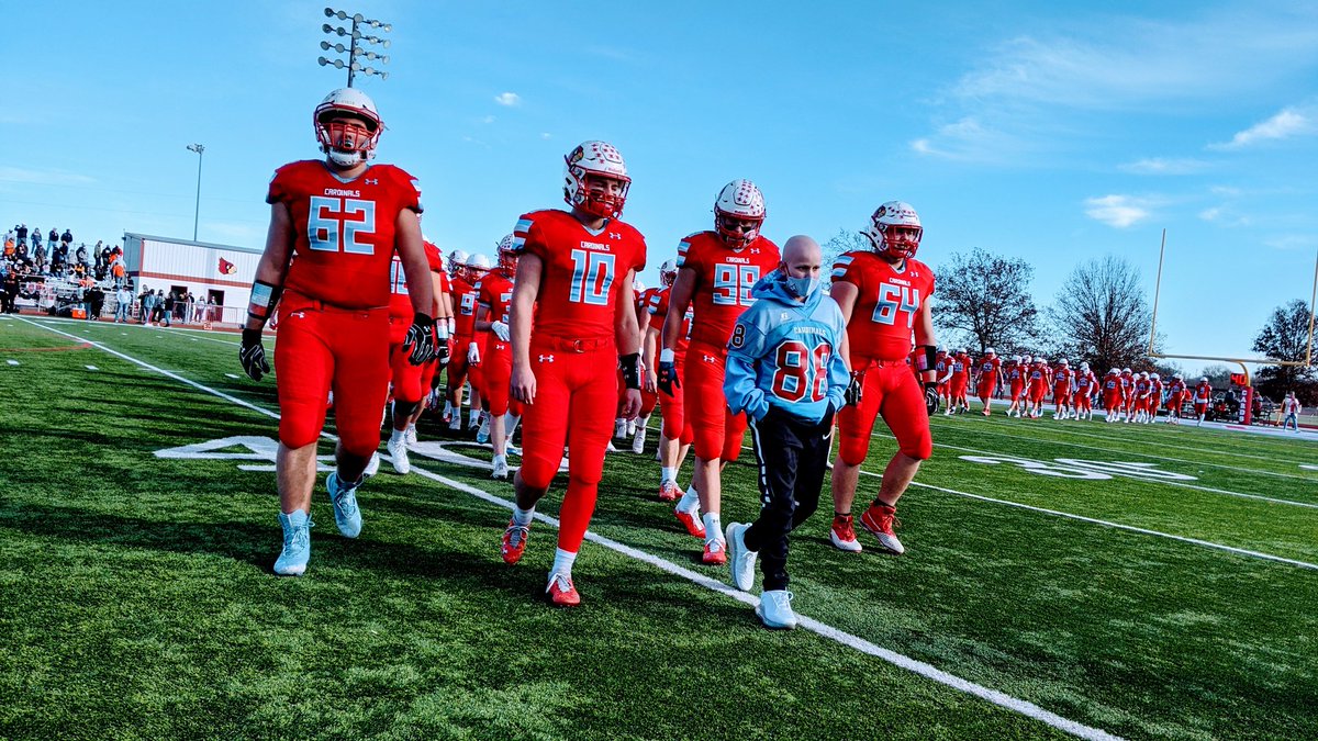 Christian Heady leads the Webb City Cardinals on the field before their state semifinal game against Platte County.