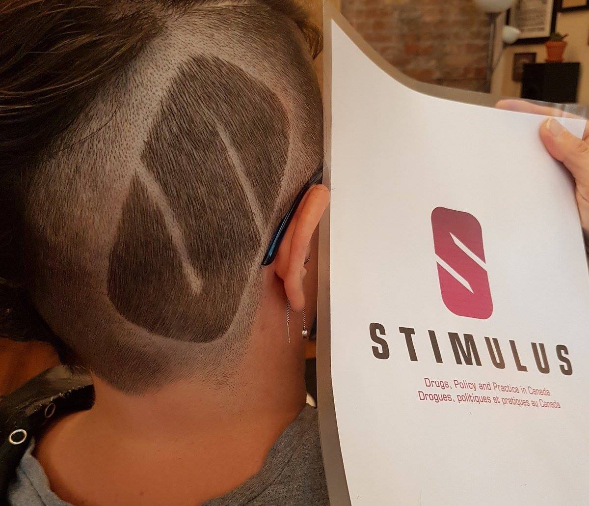 stimulus2023's tweet photo. 📢I, @ShayRD had the logo cut into my hair for the #Stimulus2018 Drugs, Policy and Practice in Canada 🇨🇦 conference.
I am 1 of the folks🗣️to how we ensured people who use drugs led the way in the organization & delivery of the event. #StimulusConnect Co-host: @CAPUDofficial 1/2 https://t.co/p0VFErBo9K