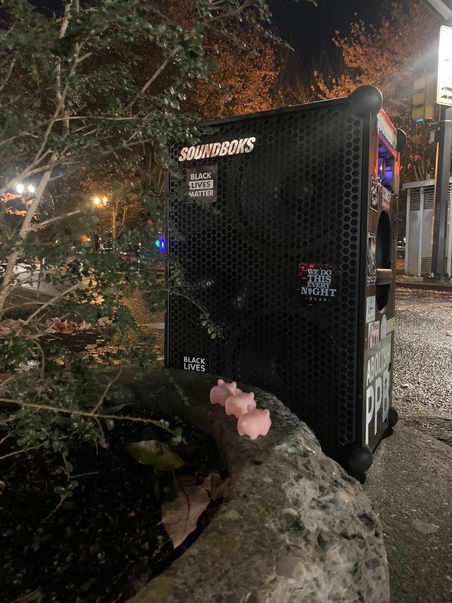 The scraggly bush is on the far left with squeaker pigs in the center and the speaker  on the right facing off with the squeaker pigs