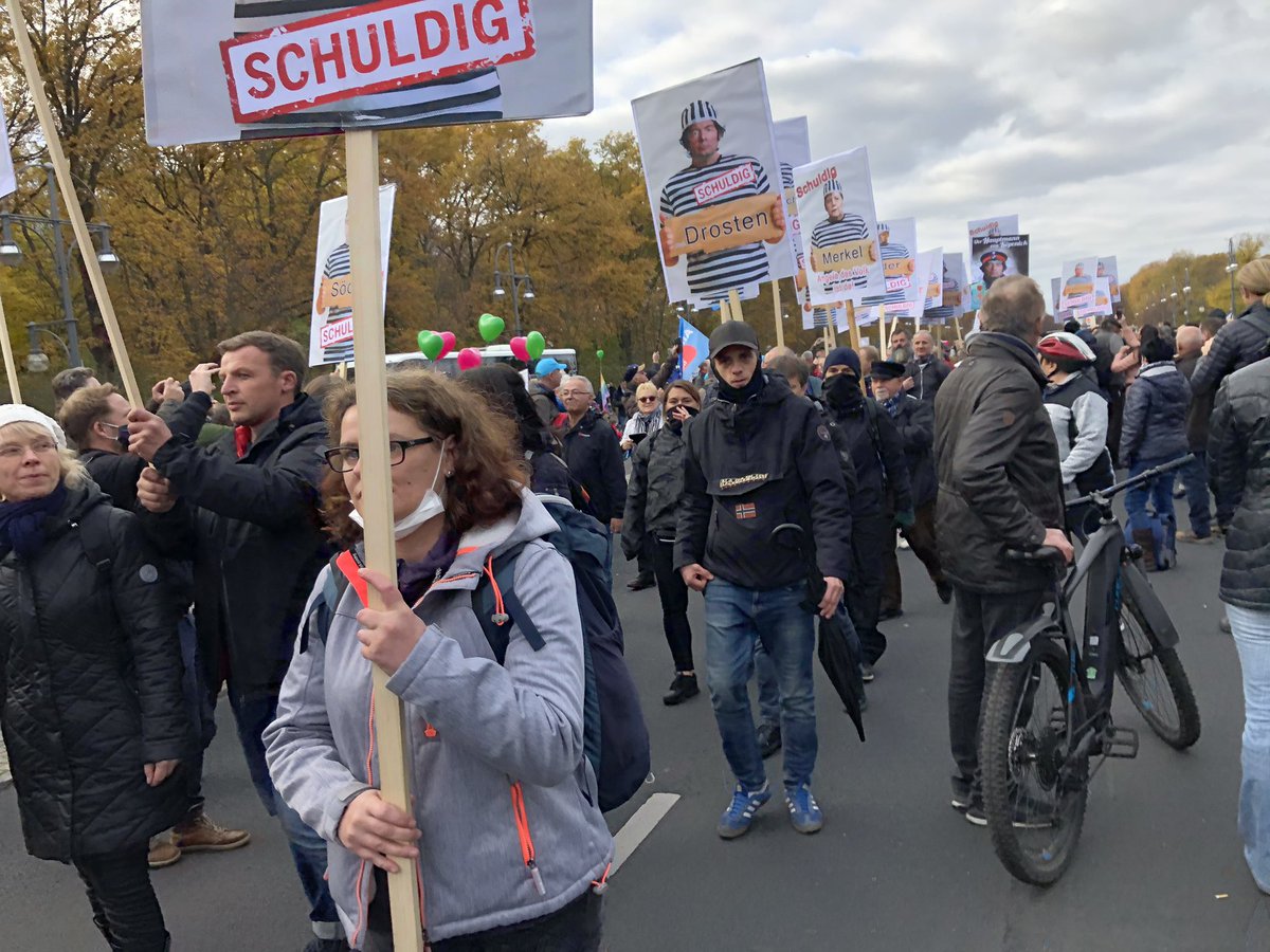 around 100 people marching down straße des 17. juni with “guilty” signs featuring politicians, virologists and journalists that the covid deniers want to imprison #b1811  #querdenken