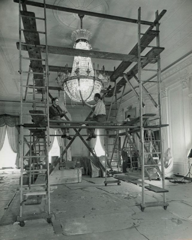 The enormous fixtures, made of cut glass and gilded brass, are so tall that they have to be cleaned at two separate levels of scaffolding. (4/8)Image Credit: Abbie Rowe, National Park Service