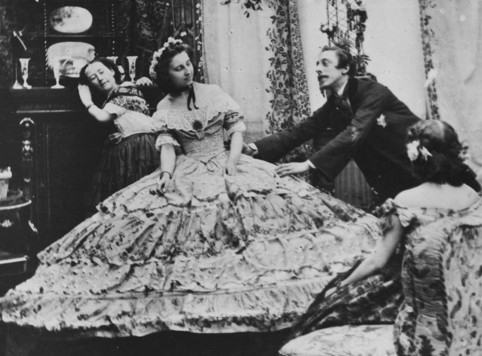 dressing with the assistance of several maids who require long poles to lift her dress over her head and other ingenious means of navigating her enormous hoopskirt.