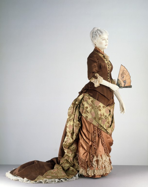 Basques, pointed waists, coat bodices, and round waists with belts were all worn with the new bustle skirts; the selection of the particular style of top was made to suit the figure of the wearer.