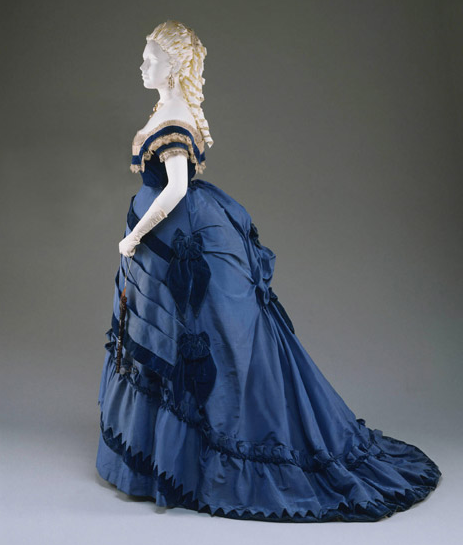 In the early stages of the fashion for the bustle, the fullness to the back of the skirts was carried quite low and often fanned out to create a train.