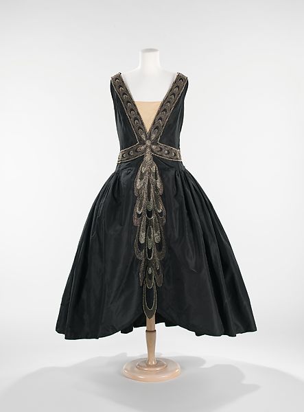 The full skirts of the war crinoline endured in the robe de style of the 1920s.