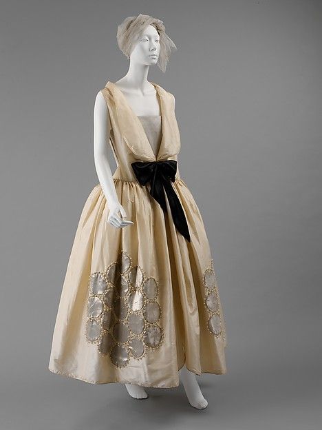 The full skirts of the war crinoline endured in the robe de style of the 1920s.