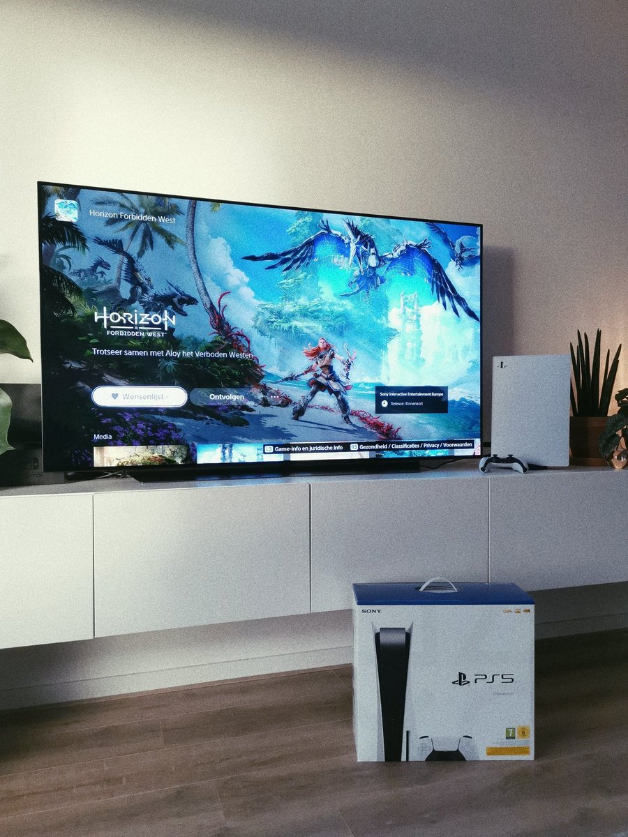 The retail box of the PS5 console on the floor in front of my TV. Screen shows the Game Hub for Horizon Forbidden West
