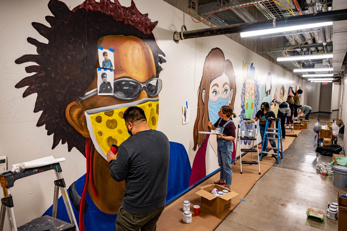jeffacarlton's tweet photo. New mural, created by students and faculty from @uta_aah, occupies a basement hallway used by masked and gowned staffers of UTA’s North Texas Genome Center, which processes campus COVID-19 tests.  
https://t.co/4ikSIROldd @utalibarts @utarlington @dvnnc https://t.co/F3sH0tMqws