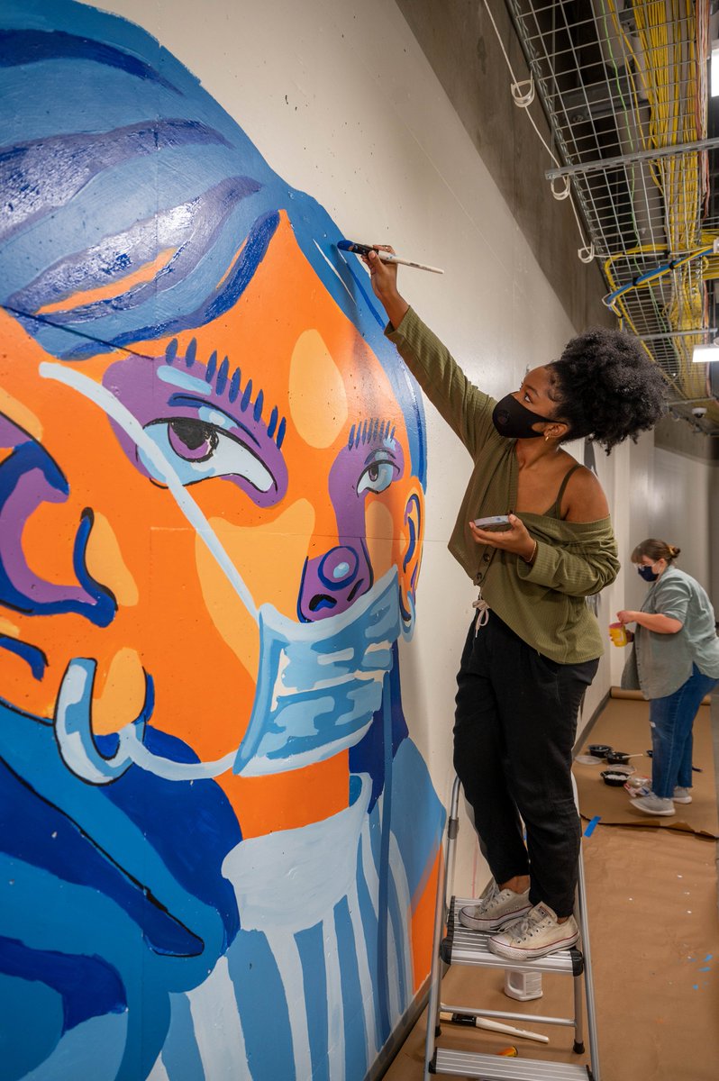 jeffacarlton's tweet photo. New mural, created by students and faculty from @uta_aah, occupies a basement hallway used by masked and gowned staffers of UTA’s North Texas Genome Center, which processes campus COVID-19 tests.  
https://t.co/4ikSIROldd @utalibarts @utarlington @dvnnc https://t.co/F3sH0tMqws