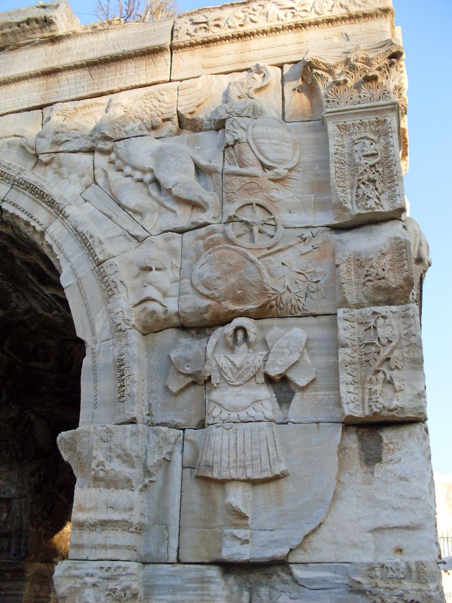 The trophaeum began as an improvised victory trophy quickly erected on the battlefield but soon became a widely recognised symbol of military victory, recreated in marble and incorporated into triumphal monuments; seen for example on the Arch of Marcus Aurelius in Tripoli, Libya.