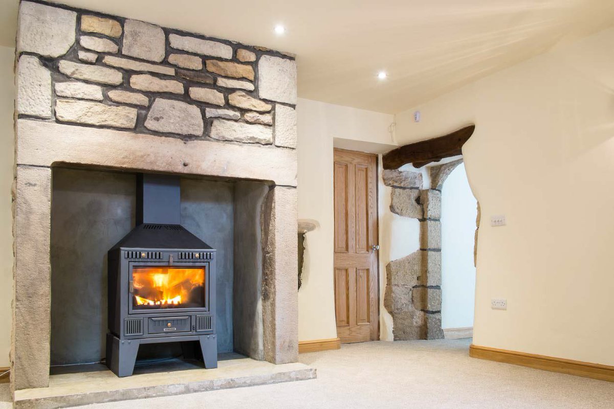 We exposed and re-built the stonework on this gorgeous fireplace during our restoration of this 19th century barn, refurbishing the beehive stove for a cosy feel.