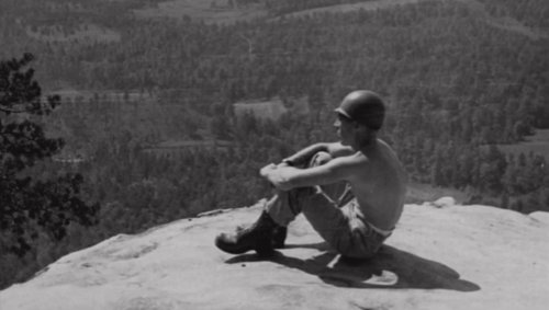 The track was just a bulldozed trail up the side of the mountain, complete with rocks, potholes, and a rain gulley that ran down the middle. Many falls occurred and many broken and sprained limbs were suffered. Pictured is G Co, 506th PIR10/