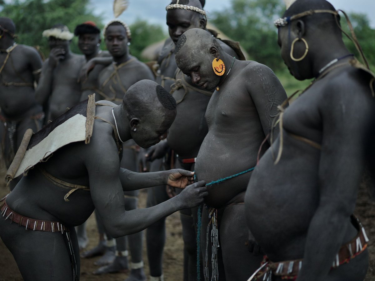 New work from Southern Ethiopia In a remote village, these naked men measuring their bellies are actually rivals in an annual competition. They have transformed their bodies into incredible shapes. This is a beauty pageant where all the contestants dream to be the fattest.