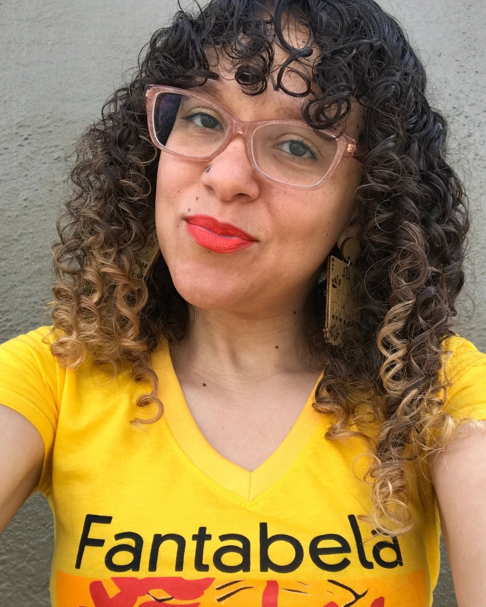 FTDcollective's tweet photo. Color Selfie #622 with olive green background and bright yellow @fantabela shirt with #Freshtodef "Si Se Puede" Earrings (meaning "Yes, we can"). I am still rocking curly bangs with @colorrichbeauty matte orange lipstick and @zennioptical glasses. 
:
:
Sending you all love and li https://t.co/HFjKwhlv5y