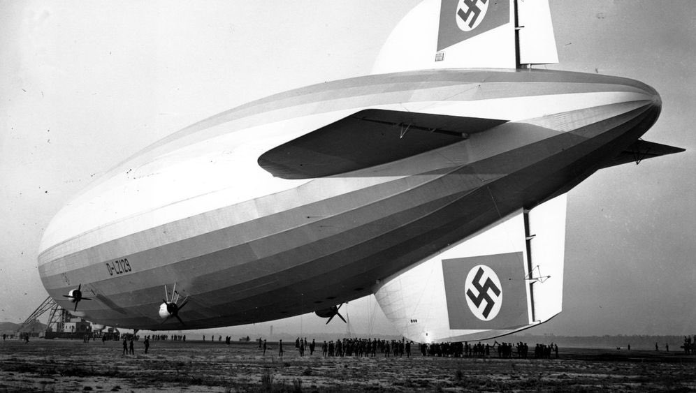 Qui dit 1936, dit forcément Hitler au pouvoir depuis 3 ans. La construction et le vol de l’Hindenburg sera le pic de la propagande nazie et une immense fierté de la part des allemands. Partout où l’Hindenburg ira, il paradera avec deux gigantesques croix gammées sur les ailerons.