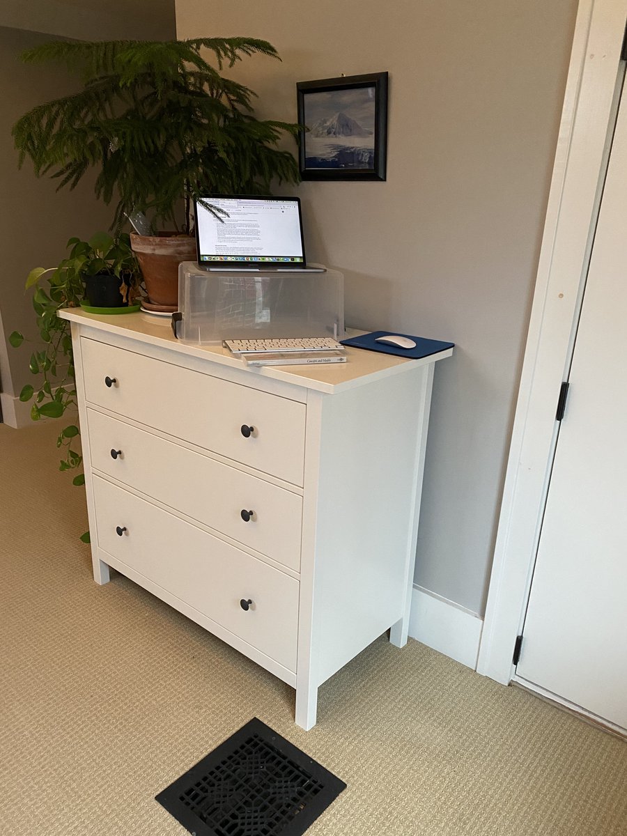 Laptop on a small tote on a dresser.