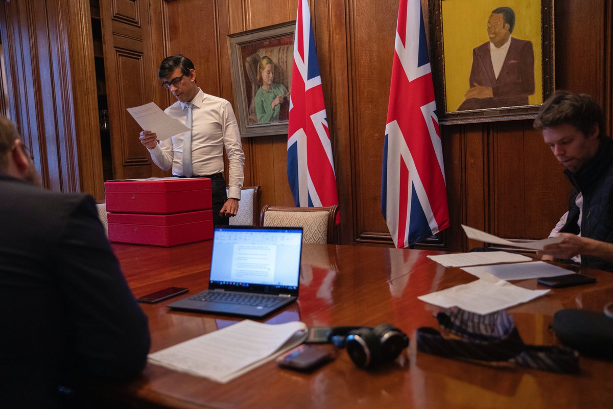 tnewtondunn's tweet photo. Brand Rishi reaches new heights. Just released by the Treasury: in a hoodie at his No10 flat's table, and practising his Spending Review speech in his No11 dining room, with red boxes masquerading as the Commons despatch box. https://t.co/tno3mdb6El