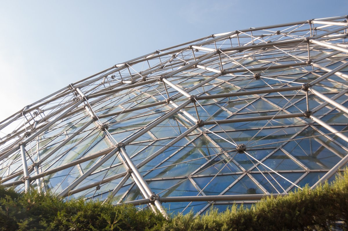 The Climatron at the Missouri Botanical Garden, completed in 1960, is a geodesic dome help up by a complex aluminum network of compressed tubes and tensioned rods.