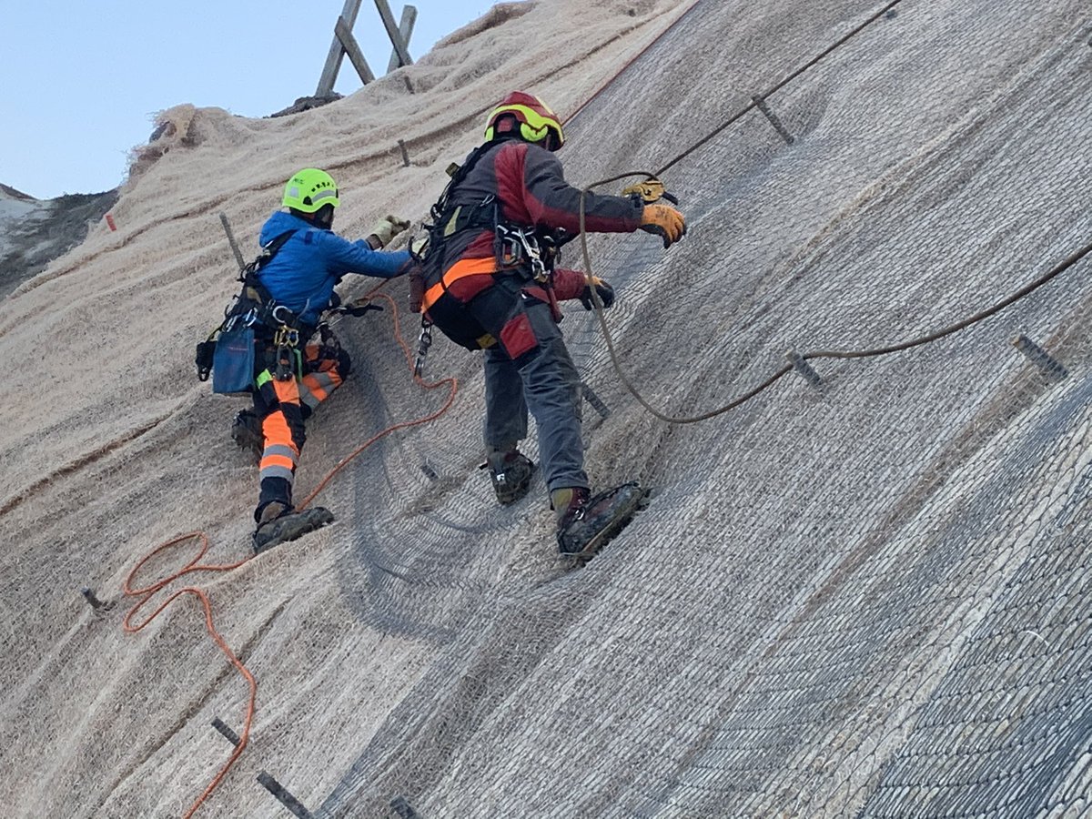 LindnerSuisse's tweet photo. Ein Teil des Geländes beim Kreisel ist so steil, dass Spezialisten für Kletterarbeiten im Einsatz sind. Verlegt wird #Howolis der Natürliche und nachhaltige #Erosionsschutz aus #SchweizerHolz. #sanktgallen #schweizerholz #baustelle #naturgefahren #klimawandel #bauingenieur #holz https://t.co/R1Aw1BU1Mk