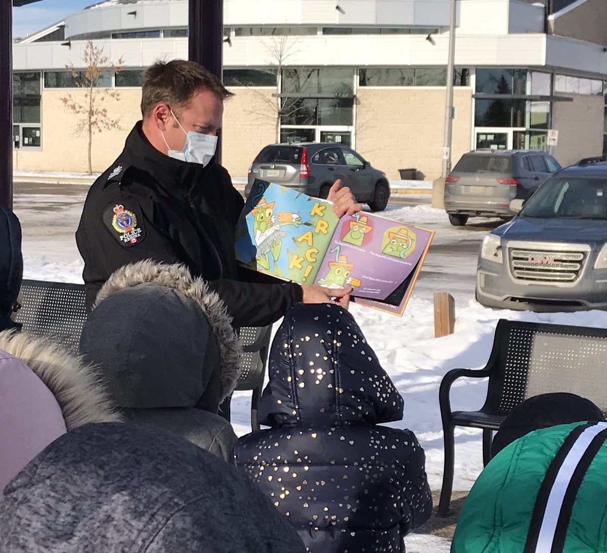 ReginapoliceCEU's tweet photo. Cops &amp; Readers during Covid looks a little different. With the warmer weather @reginapolice &amp; @OfficialRPL did our reading on the playground. With everyone wearing a mask (even those faces you can't see), the students at @StAugustineRCSD were still very enthusiastic &amp; engaged! https://t.co/lQiCZzCiDr
