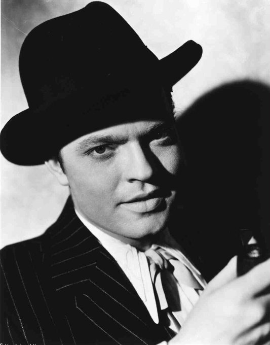 publicity portrait of Orson Welles for Citizen Kane, wearing a hat and pin-stripe jacket