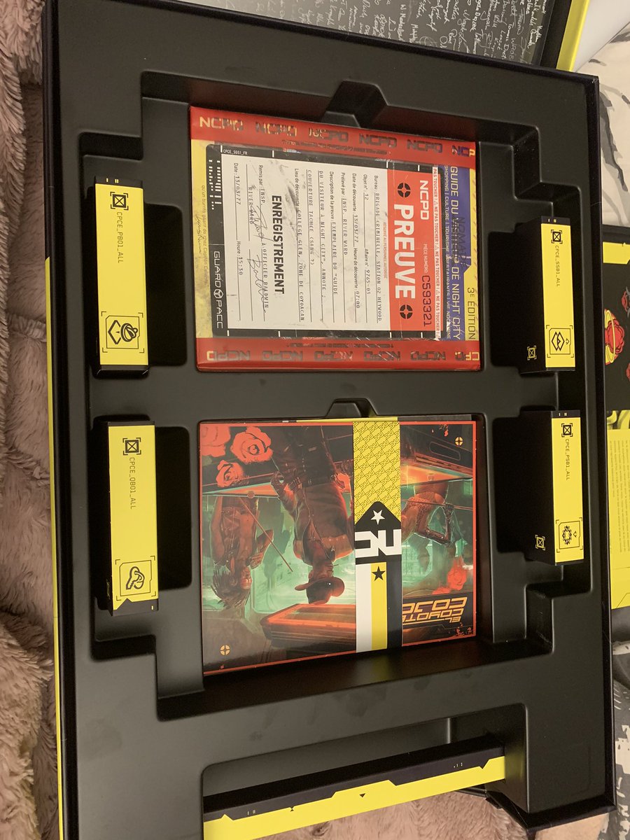 Lorsqu’on enlever l’artbook on peut découvrir :-Un sac plastique très marrant avec la mention « preuve » comme si c’était une pièce à conviction contenant un guide de la ville-Un steelbook-4 « boites » de munitions contenants des pins, stickers, porte clés, écussons