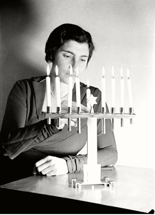 A Jewish woman lighting Hanukkah candles, Germany in the 30’s.