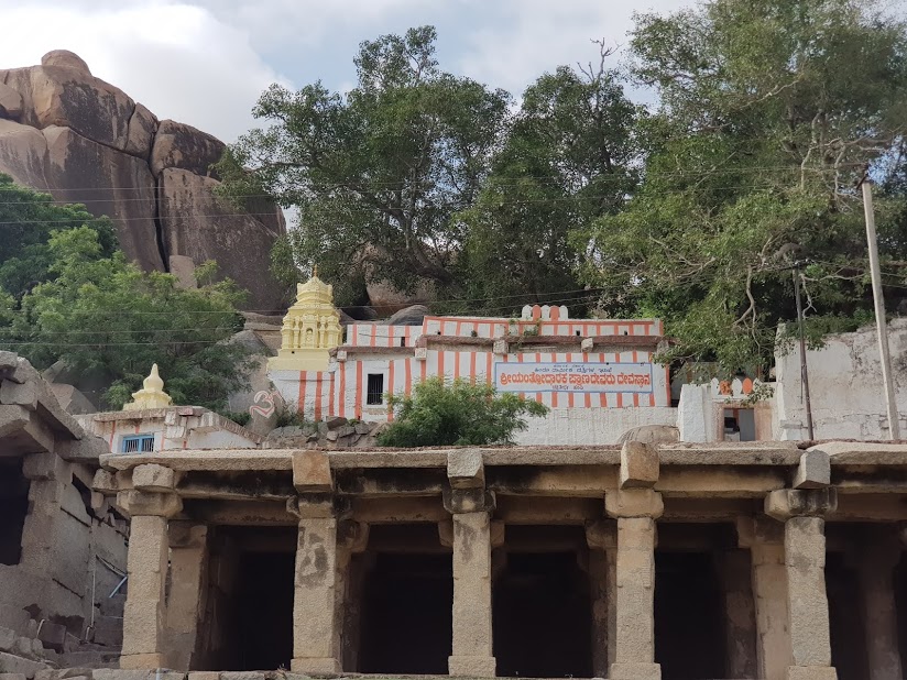 The shrine is located on top of a small hillock. The outer walls are painted with white and saffron vertical strips. A flight of steps ends in front of the temple courtyard. In the courtyard a number of snake stones are installed around the foot of a large sacred fig tree.(5)