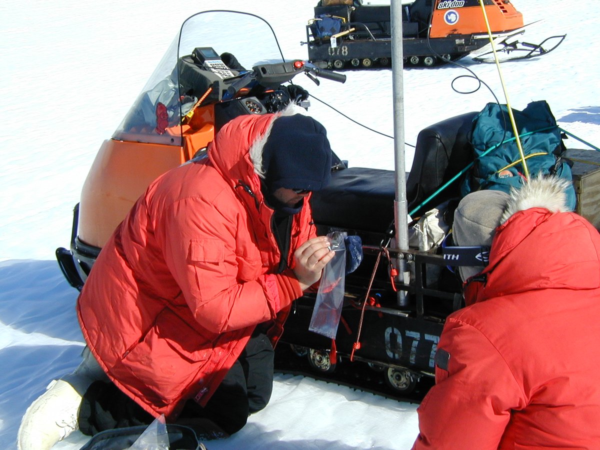 12-11-2000 When a meteorite is found, the team gathers and the finder puts the meteorite in a bag with a field number and the location measured by GPS. Here's me collecting 12878, turned out to be a CM2 chondrite, MET 001012  #ANSMET2000