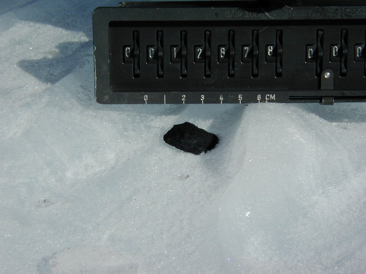 12-11-2000 When a meteorite is found, the team gathers and the finder puts the meteorite in a bag with a field number and the location measured by GPS. Here's me collecting 12878, turned out to be a CM2 chondrite, MET 001012  #ANSMET2000