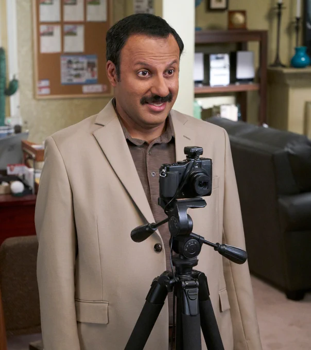 Rizwan Manji as Ray, ready to take some photographs in his job as a photographer.
