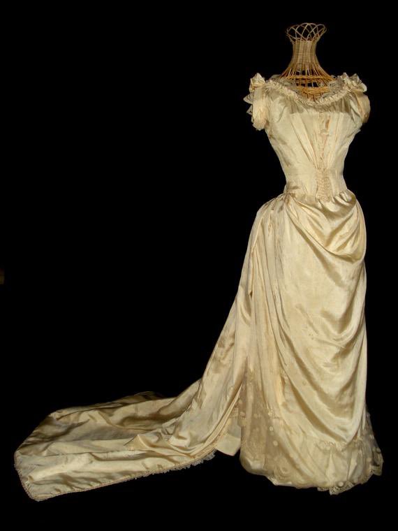 the plunging neckline and lack of sleeves would have been absolutely unacceptable during the daytime, but as evening wear? that's a different story.(though she should be wearing a pair of white, elbow- or near-elbow-length gloves.)