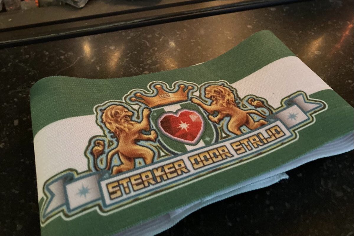 Vandaag is onze teamcaptain John Jongeneel verrast door Rotterdam Sportsupport  met de mooie aanvoerdersband Omarm Rotterdam. De unieke groen-witte band met het stadswapen staat voor diversiteit en inclusie in de sport. Saamhorigheid, enthousiasme, elkaar steunen en Trots!