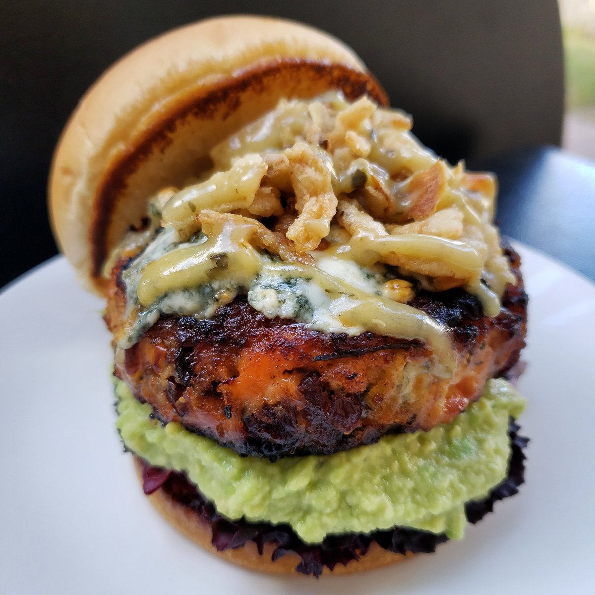 Smoky Lonestar Salmon Burger On A Bed Of Red Leaf Lettuce & Guacamole With Blue Cheese Onion Crisps, Cilantro Truffle Lime Sauce On A Butter Toasted Brioche Bun
#Salmon #AtlanticSalmon #SalmonBurger #FishBurger #SmokedSalmon #Smoked #WoodFired #TraegerGrills #BBQ #BBQLovers