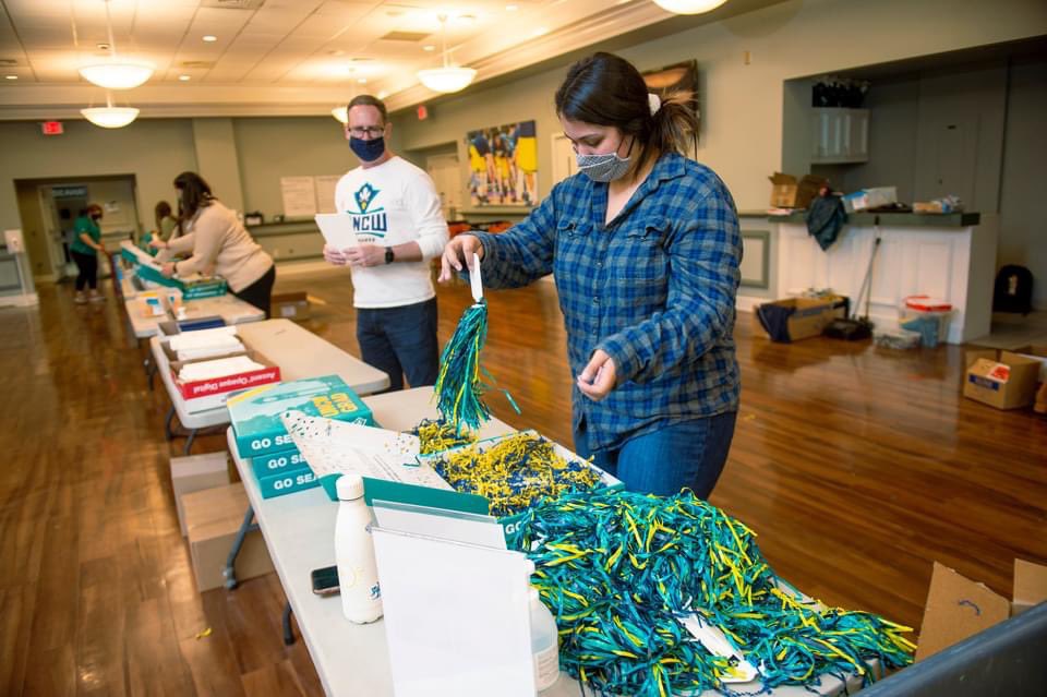 UNCWilmington's tweet photo. Graduation may be different this year, but that’s not stopping the Seahawk family from making sure our graduates can celebrate in style. Volunteers from across campus have packed special boxes to be sent to our Class of 2020 grads to commemorate their accomplishment. #UNCW2020 https://t.co/r2HsUUvO3r