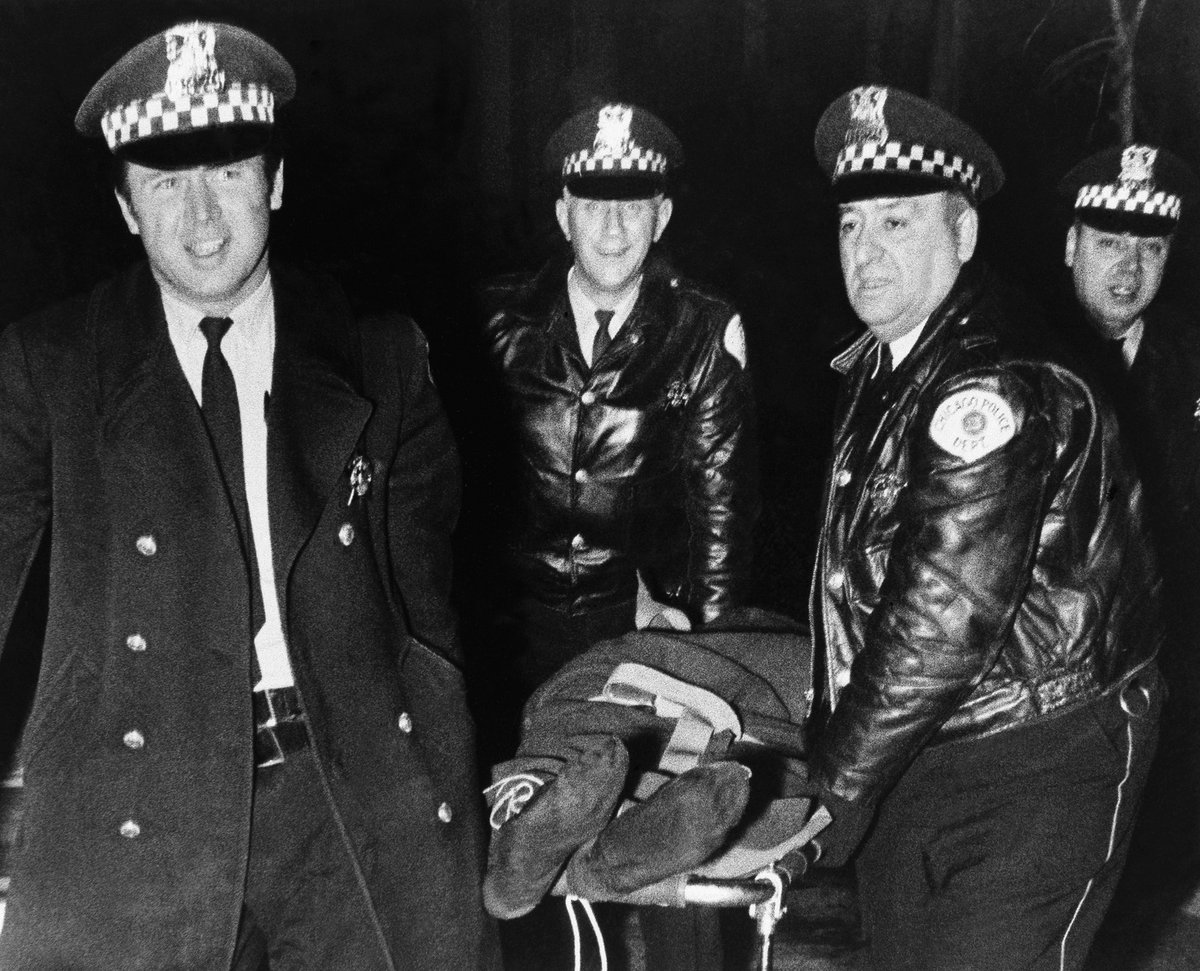 On the night of Dec. 4, 1969, Chicago police drugged Chairman Fred and stormed his apartment. Cops executed Fred with 99 bullets as he lay next to his pregnant wife. In this photo, Chicago police gloat over their murder.