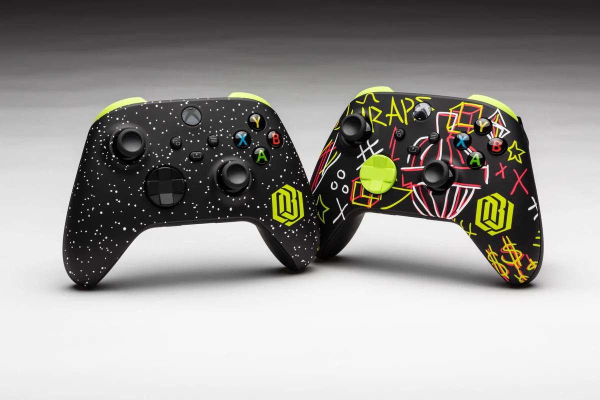 Two Custom Xbox Wireless controllers, with neon green accents and designs from Odel Beckham Juniors dream depicted on them. 
