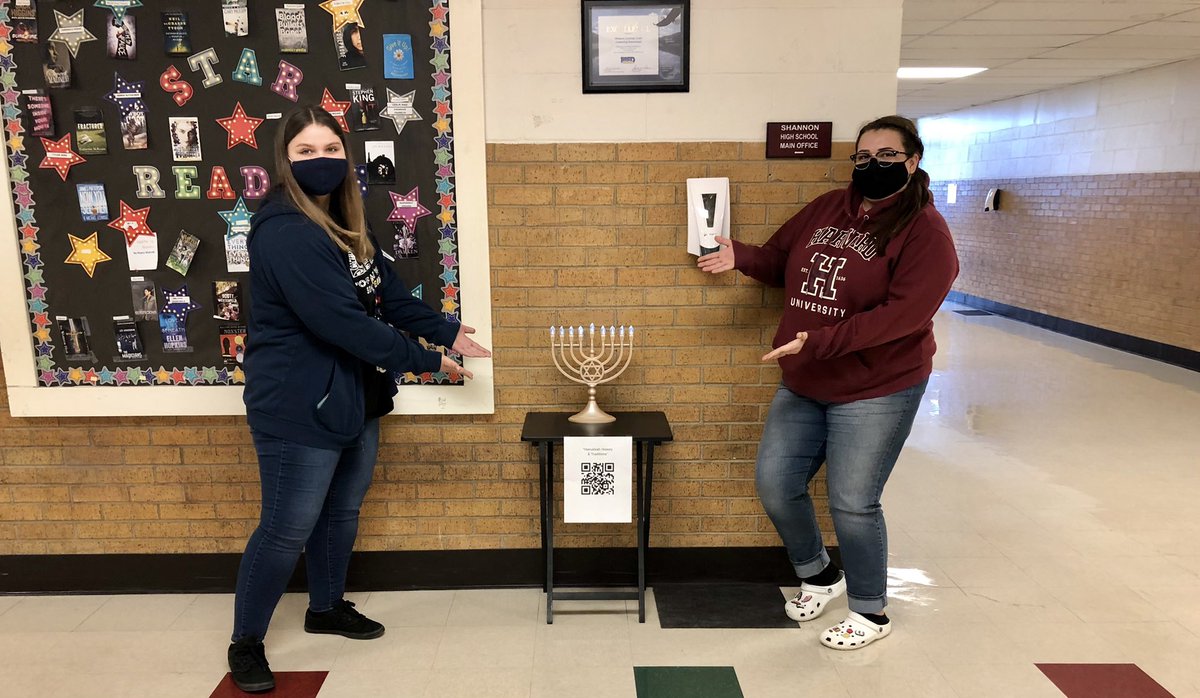 Two people by Menorah.