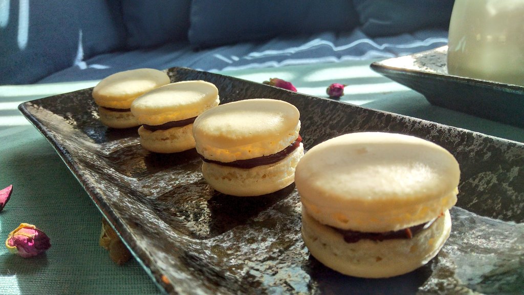 Four plain macaron cookies with chocolate ganache filling.