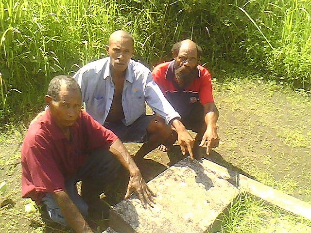 Men of Oimbari's extended family, including his only son Martin (in morone shirt) at his grave in 2013 with Wardman Ogamie, Chairman of Raphael Oimbari Foundation, at Hanau village, Ijivitari, Oro province.The Foundation seeks to develop the local Orokaiva community.FB photo.