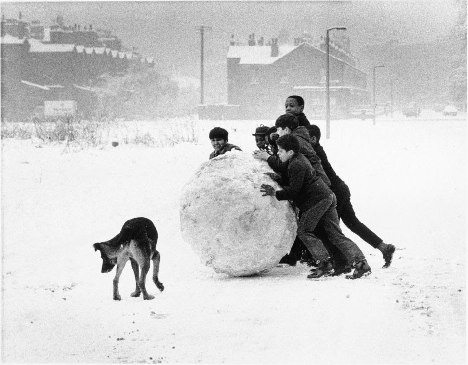 Day 6.The Ghosts of Christmas past  #AdventCalendarKids in Manchester rolling a huge snowball, 1968.Photo Shirley Baker