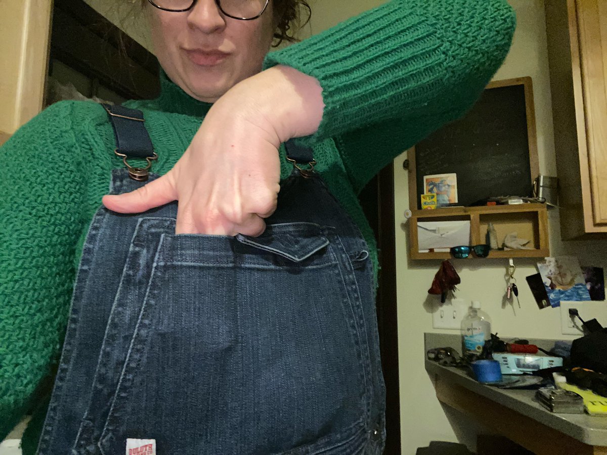 One, the smaller one, is open. The larger, has the flap. Here they are. My whole hand, with fingers half-spread, in the big pocket. Two to three fingers in the other, and I can’t reach the bottom. Good for longer items... candy bars, for example.