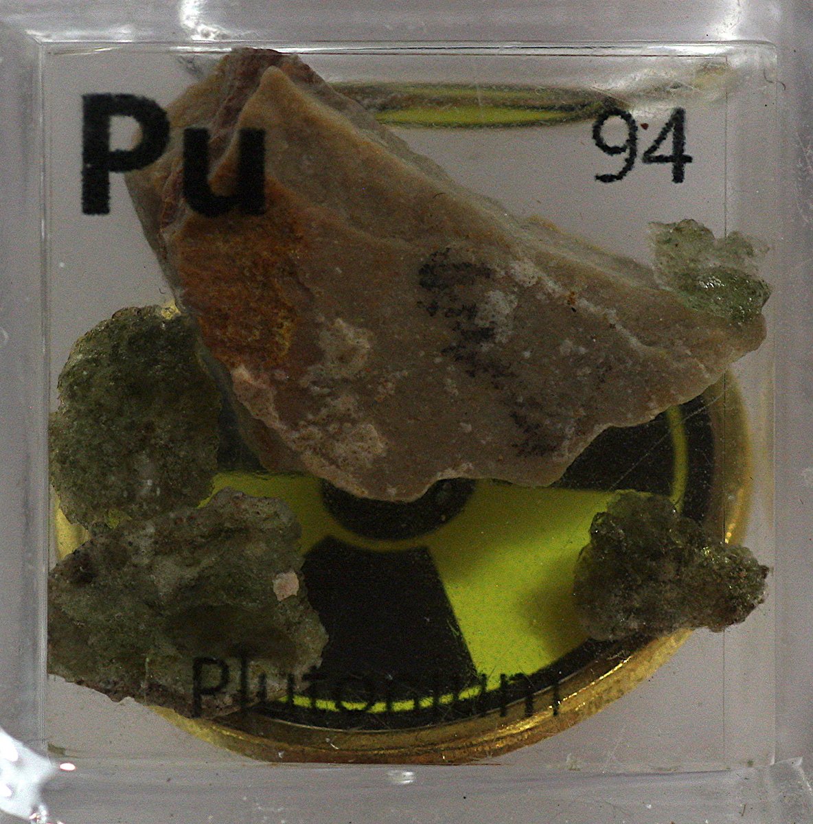 Plutonium  #elementphotos. Uranium ore (brown rock) naturally contains trace amounts of Pu (neutrons from decaying U-238 can strike other U-238 atoms to give Pu). Green glass-like rocks are Trinitite, which is a residue from the 1945 Pu-based Trinity nuclear bomb test.
